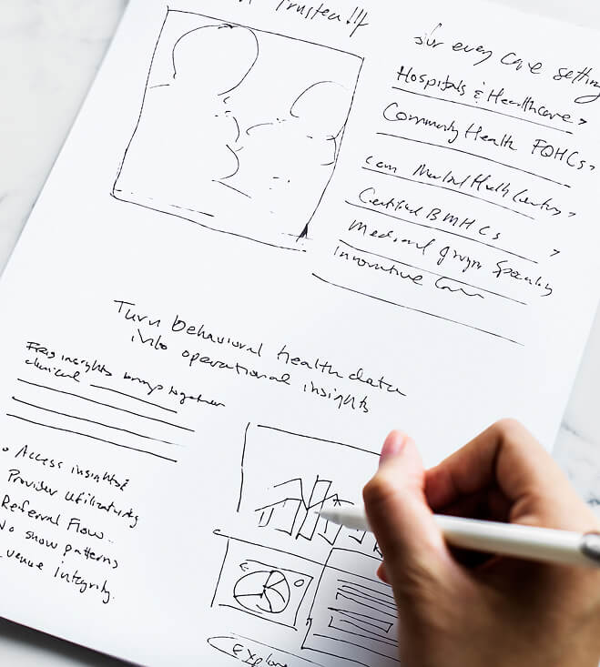 Hand holding a pen over a notes page with rough sketches and bullet points about community health and hospitals.