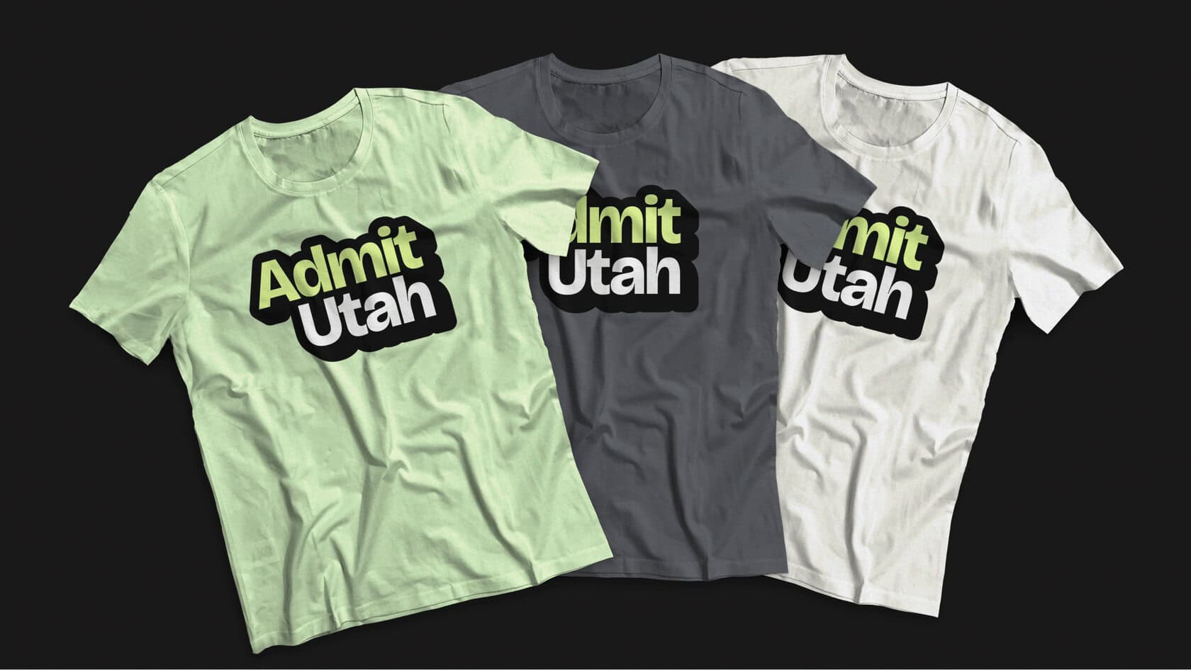 Three T‑shirts in mint, gray, and white each feature a bold black-and-cream 'Admit Utah' logo across the chest.