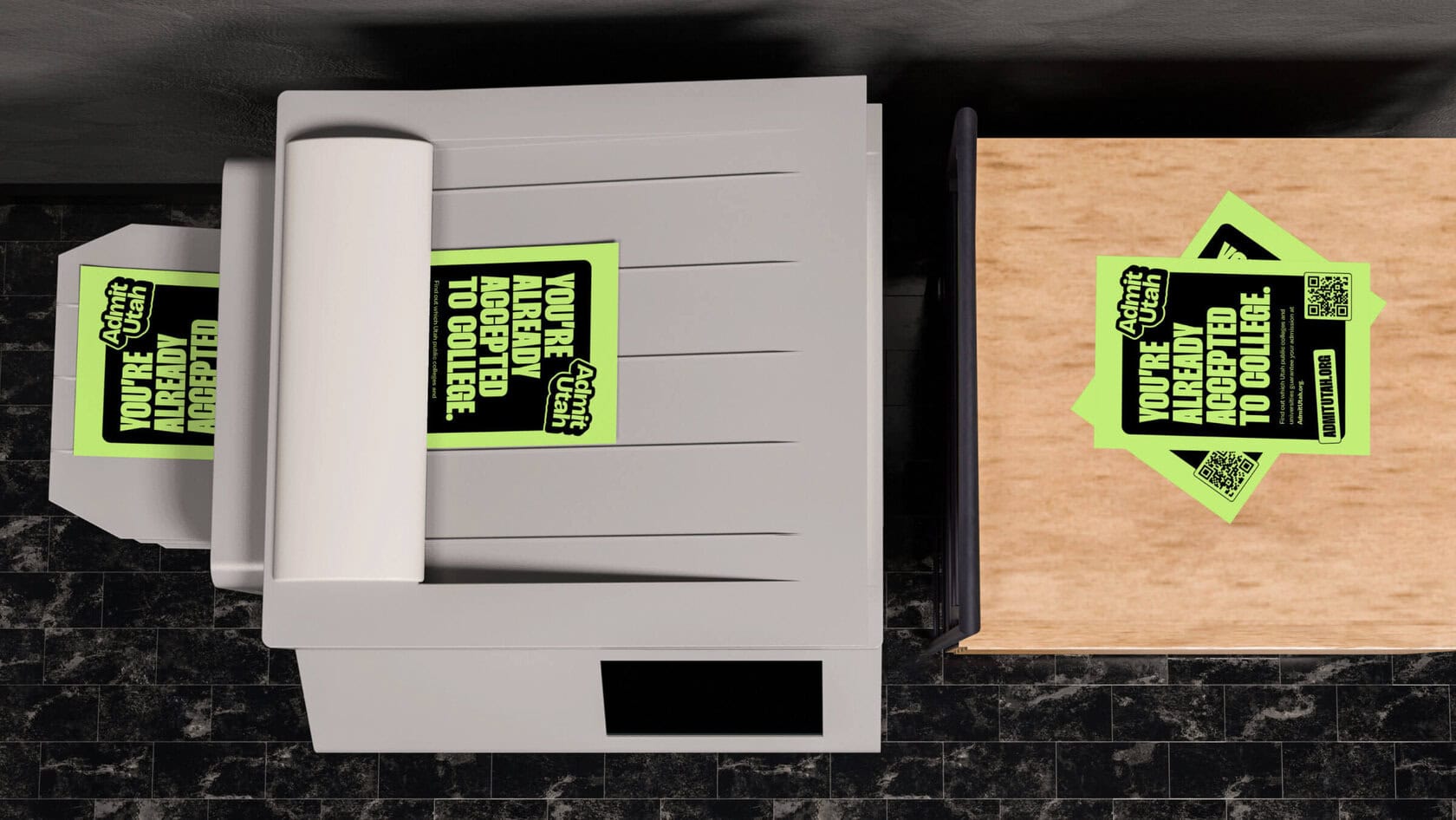 Top-down view of a printer with neon green flyers sticking out of the paper tray; a matching flyer rests on a wooden desk to the right of the printer.